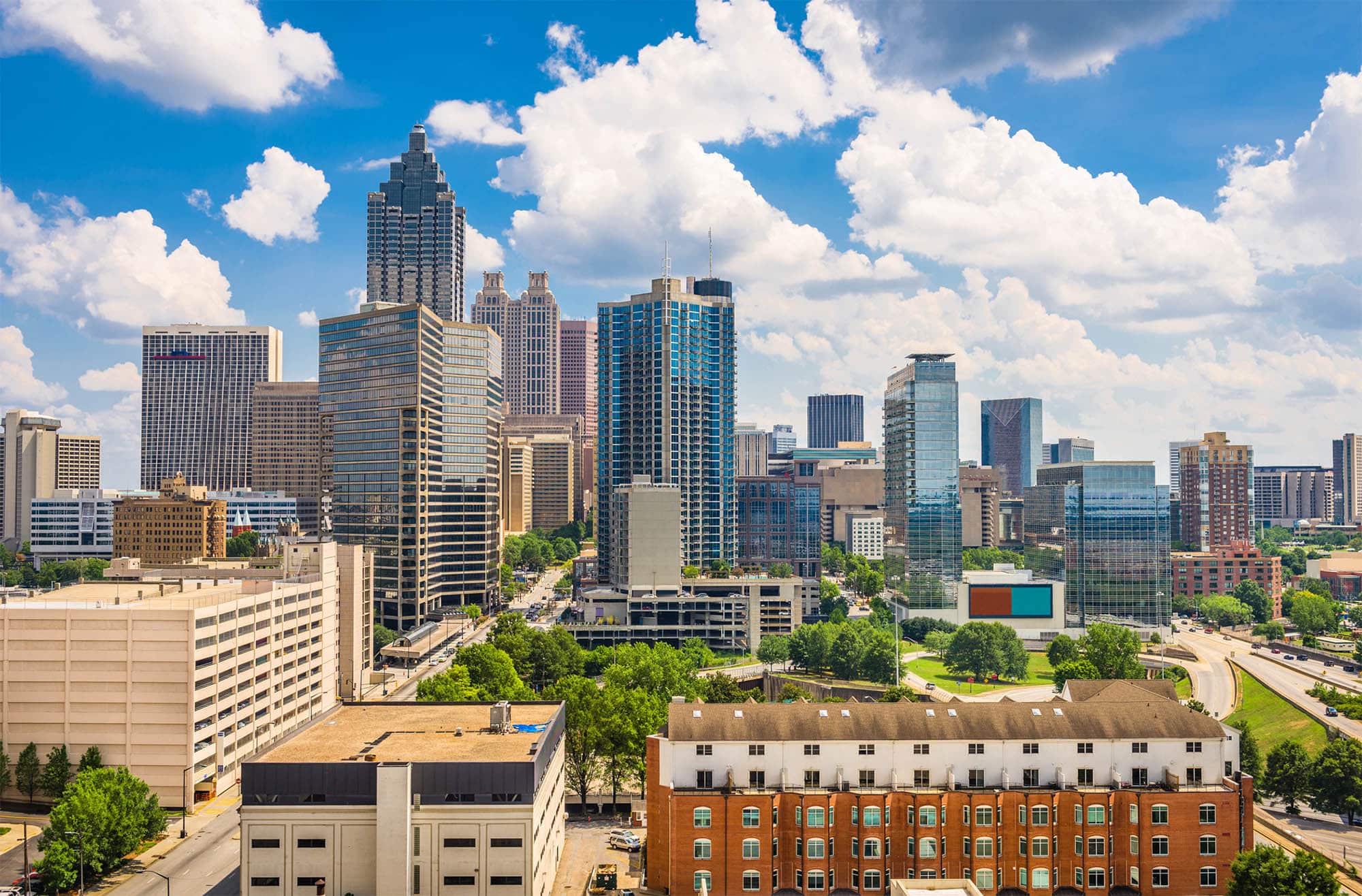 Atlanta skyline on a sunny day with scattered clouds.