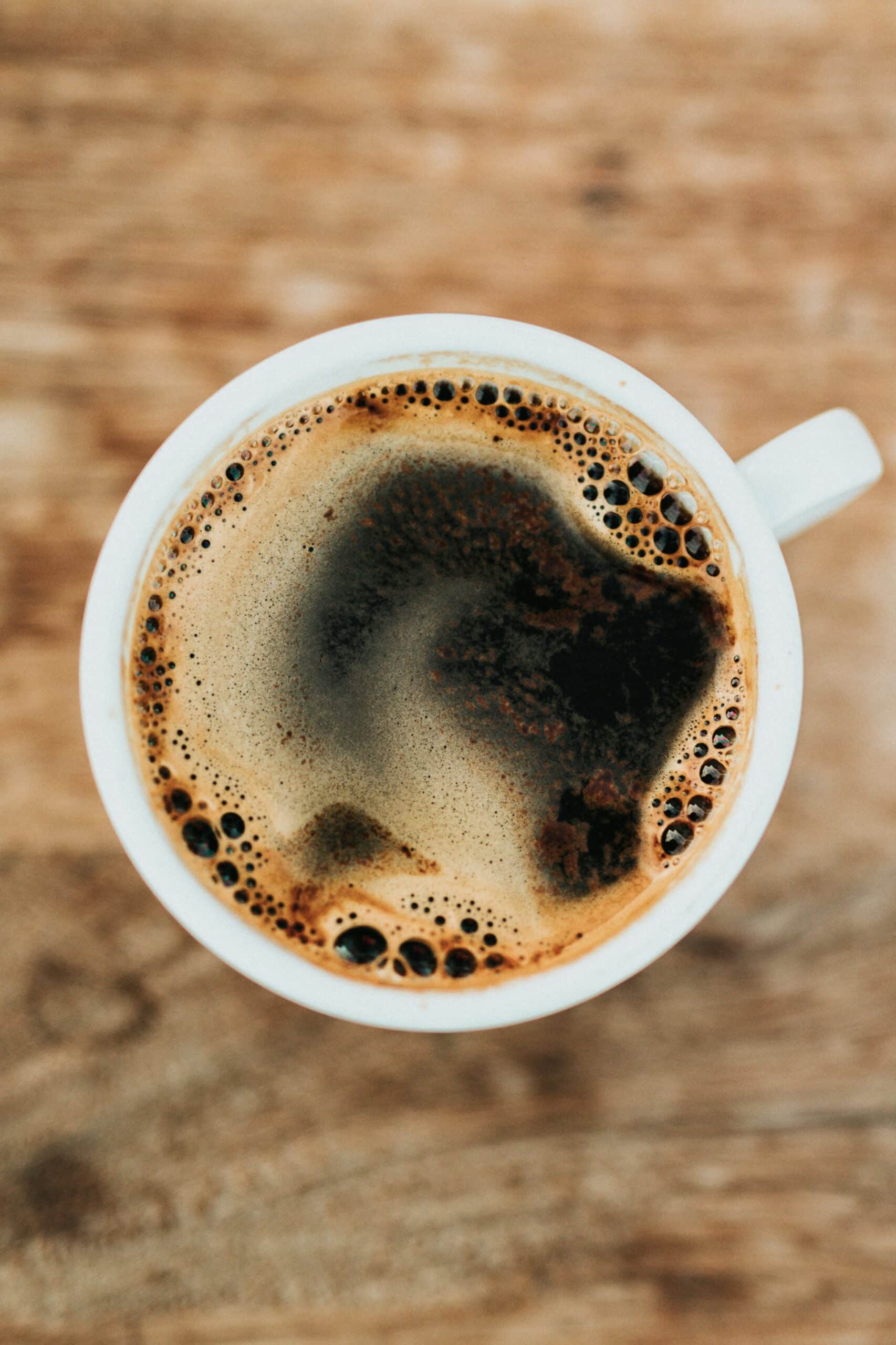 A cup of coffee on a wooden table.